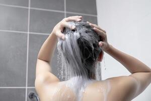 Frau Waschen Haar mit Shampoo und Dusche im das Badezimmer. ai generiert foto