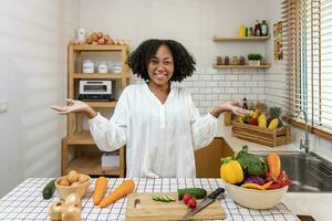afrikanisch amerikanisch Hausfrau ist zeigen Vielfalt von organisch Gemüse zu bereiten einfach und einfach Cajun Süd- Stil Salat Mahlzeit zum vegan und Vegetarier Seele Essen Konzept foto