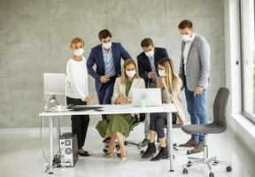 maskierte Menschen in einem Büro foto