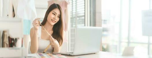 asiatisch Frau Designer Job mit Laptop Computer zum online Sozial Medien Marketing Banner Größe Hintergrund foto