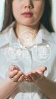 Geschäftsfrau auf verschwommen Hintergrund halten Hologramm mit Geschäft Symbole im ihr Hände foto