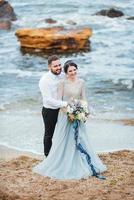 das gleiche Paar mit einer Braut in einem blauen Kleid zu Fuß foto