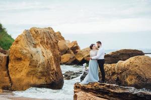 das gleiche Paar mit einer Braut in einem blauen Kleid zu Fuß foto