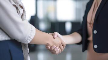 Geschäft Handschlag zwischen zwei Frauen. schließen hoch. Innerhalb ein modern hell Büro. generativ ai. foto