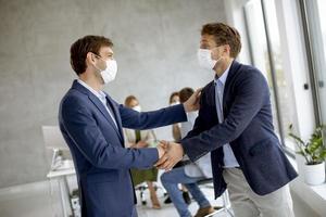 zwei maskierte Geschäftsleute, die eine Vereinbarung treffen foto