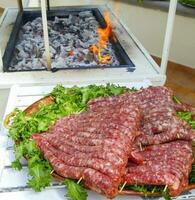 Tablett mit Würste bereit zu Sein gekocht auf das Grill. foto