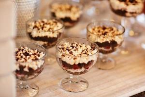 Tiramisu-Desserts in einer Glasdessertschale auf dem Tisch bei der Party foto