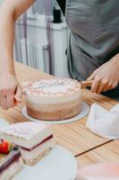 ein Stück von Schokolade Kuchen im das schneiden. Vorbereitung von Mousse Kuchen beim ein kulinarisch Meister Klasse. Kochen beim heim, hausgemacht Essen foto