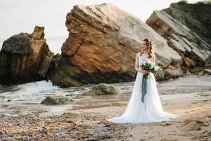 Braut mit einem Hochzeitsstrauß am Ufer