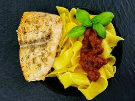 Italienisch Papadelle Pasta mit ein geröstet Lachs Steak und Gemüse foto