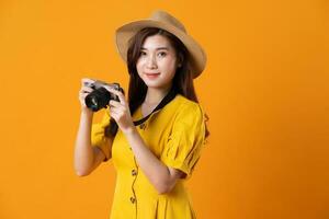Porträt von schön asiatisch Mädchen tragen Gelb Kleid auf Orange Hintergrund foto