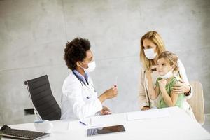 Kinderarzt im Gespräch mit Eltern und Kind foto