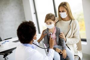 Nahaufnahme einer Kinderarztuntersuchung mit Masken auf foto