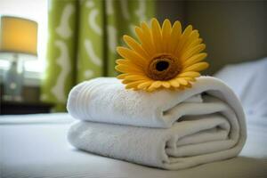 Stapel von Handtücher und Blume auf Bett im Hotel Zimmer. hell Gerbera wie herzlich willkommen Geste, Zimmer Service, Unterkunft Konzept, Kopieren Raum foto