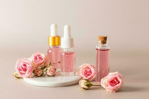 ein einstellen von Kosmetika im verschiedene Flaschen basierend auf das Extrakt von Rose Blütenblätter auf Pastell- Hintergrund. Gesichts- Haut Pflege. natürlich Kosmetika. foto
