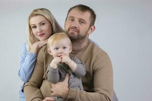 auf ein grau Hintergrund Familie von drei Menschen Mama Papa und Baby. foto