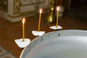 Teil von das Taufe Schriftart zum ein Kind mit zündete Kerzen. Kirche Hintergrund zum orthodox Taufe. foto