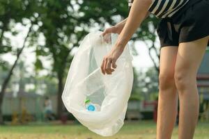 speichern Erde. Freiwillige wählen oben Müll Müll beim das Park und Plastik Flaschen sind schwierig zersetzen verhindern Schaden. Erde, Umfeld, Begrünung Planet, reduzieren global Erwärmen, speichern Welt ,Verschmutzung foto