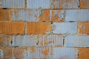 Peeling Farbe auf ein Backstein Mauer im Schatten von grau und Sahne mit Flecken von ausgesetzt Backstein foto