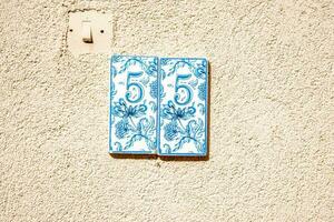 Nummer Teller 55, Blau Farbe Teller auf Beige Mauer. foto