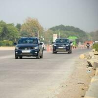 Neu Delhi, Indien - - April 16, 2023 - - Aussicht von Fahrzeuge Vorbeigehen durch das Main Straße in der Nähe von indra Gandhi International Flughafen Delhi beim Zwerg Verknüpfung Straße foto