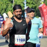 Neu Delhi, Indien - - April 16 2023 - - Vedanta Delhi Hälfte Marathon- Rennen nach covid im welche Marathon- Teilnehmer Über zu Kreuz das Fertig Linie, Delhi Hälfte Marathon- 2022 foto