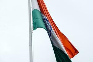 Indien-Flagge, die hoch am Connaught-Platz mit Stolz auf den blauen Himmel fliegt, Indien-Flagge flattert, indische Flagge am Unabhängigkeitstag und Tag der Republik Indien, Schuss nach oben geneigt, indische Flagge schwenkend, Har Ghar Tiranga foto