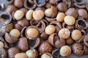 Bio-Macadamia-Nüsse und Schale auf Holztisch foto