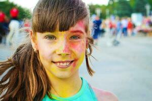 glücklich Mädchen zeigt an Klasse mit holi malen. foto