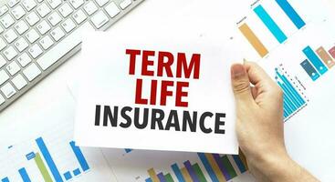 Geschäftsmann halten ein Karte mit Text Begriff Leben Versicherung .Klaviatur, Diagramm und Weiß Hintergrund foto
