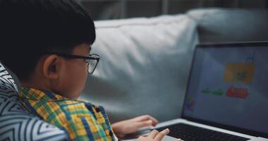 Clever Junge verwenden Laptop Computer zu Lernen online beim Zuhause foto
