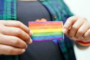 asiatische frau mit regenbogenflagge, lgbt-symbolrechten und geschlechtergleichstellung, lgbt-stolzmonat im juni. foto