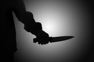 schließen oben von männlich Hand halten ein Messer zu stechen jemand. Verbrechen und Kriminalität Konzept foto