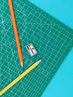 Grün Schneiden Matten , Stift Zeichnungen , einstellen Winkel Werkzeug , Rahmen Lineal auf Blau Hintergrund foto
