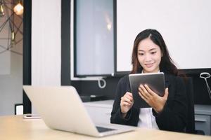 Frau im Büro mit digitalem Tablet foto