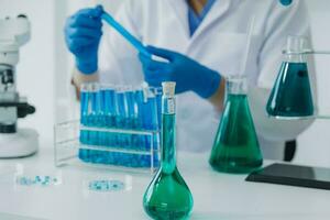 Hand von Wissenschaftler mit Prüfung Tube und Flasche im medizinisch Chemie Labor Blau Banner Hintergrund foto