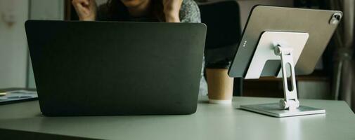 junger erwachsener glücklich lächelnder hispanischer asiatischer student mit kopfhörern, der über online-chat-meetings mit laptop auf dem universitätscampus oder im virtuellen büro spricht. College-Studentin, die aus der Ferne lernt. foto