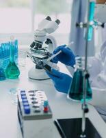 Hand von Wissenschaftler mit Prüfung Tube und Flasche im medizinisch Chemie Labor Blau Banner Hintergrund foto