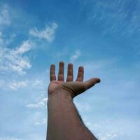 Hand hoch gestikulierend in den blauen Himmel, Gefühle und Emotionen foto