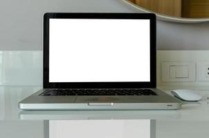 Computer-Laptop-Modell und Maus mit weißem leerem Bildschirm auf Tisch. foto