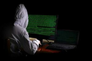Frauen Hacker bricht in Regierungs-Datenserver ein und infiziert ihr System mit einem Virus an seinem Versteck, dunkelblaue Atmosphäre, Kapuzenfrau mit Laptop mit Binärcode-Hintergrund, Malware-Konzept