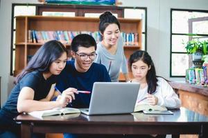 asiatische Studenten, die in der Bibliothek arbeiten foto