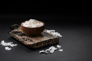 Weiß trocken Kokosnuss Flocken im ein hölzern Schüssel bereit zum Herstellung Nachspeisen foto