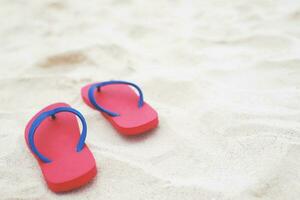 Meer am Strand Fußabdruck Menschen auf dem Sand und Pantoffel der Füße in Sandalen Schuhe auf Strandsand Hintergrund. Reiseferienkonzept. foto