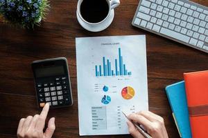 Geschäftsbuchhaltungskonzept, Geschäftsmann, der Stift zeigt mit Aktien-Maket-Daten-Finanzdiagramm und Taschenrechner für die Berechnung des Finanzplanpapiers im Büro. foto