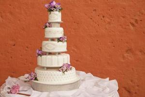 weiße Hochzeitstorte mit Blumen verziert foto