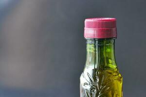 Flasche von Olive Öl gegen schwarz Hintergrund foto
