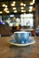 Blau Farbe Kaffee Tasse mit ein Cafe Hintergrund foto