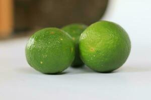 Grün Zitronen mit auf ein Weiß Hintergrund foto