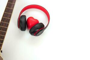 akustisch Gitarre, Kopfhörer und rot Herz auf ein Weiß Hintergrund. Liebe, Unterhaltung und Musik- Konzept. foto